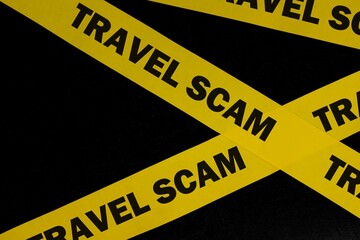 Travel scam alert, caution and warning concept. Yellow barricade tape with word in dark black...