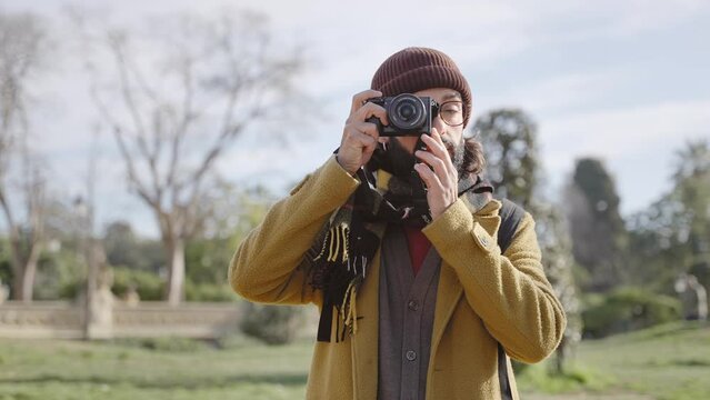 Traveler man photographer wearing beanie and scarf taking photo in winter vacation