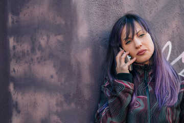 sad lonely woman talking with phone on lilac wall, equality concept