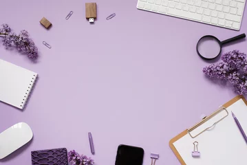 Poster Minimal workspace on a home office desktop with notebooks, keyboard, stationery, coffee cup, bouquet of lilac flowers, smartphone. Flat lay, top view © Sunshine