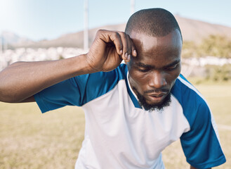Naklejka premium Black man is tired, face and football player on outdoor field, playing game or soccer training with energy and exhausted athlete. Team sport, sweating and fitness, challenge and fatigue with workout