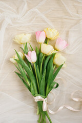 View from above tulip flowers pink and yellow color with copy space on beige background for womens day, 8 March Valentines day, 14 february. Flat lay style, top view, mockup, template, overhead