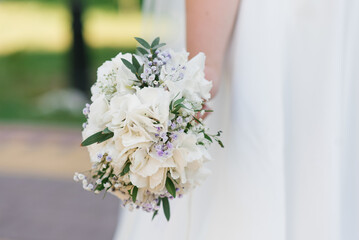 Wedding bouquet with white hydrangea in the hands of the bride
