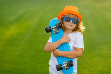 Summer kids. Childhood and fashion. Cute child with skateboard on summer park background. Funny kid...