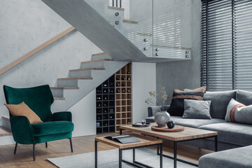 Stylish composition of living room interior with corner grey sofa, green velvet armchair, coffee table, wooden floor, design furniture and personal accessories. Modern home decor. Template.