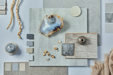 Flat lay of creative architect moodboard composition with samples of building, textile and natural materials and personal accessories. Top view, grey background, template.