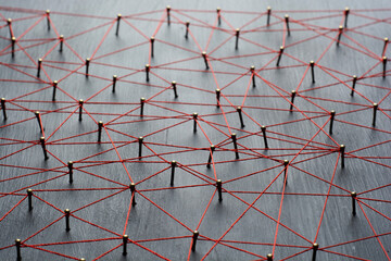 Background with selective focus. Abstract concept idea of network, social media, internet, teamwork, communication. Thumbtacks linked together by red thread. Isolated. Entities connected