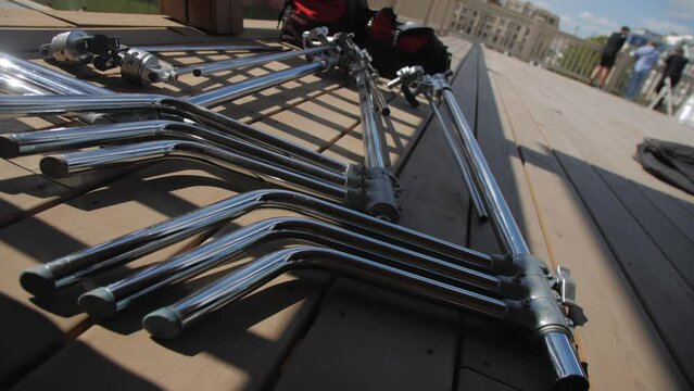 Metal pipes for adjusting light reflector for film making on street. Filming crew prepares set for shooting scene for movie