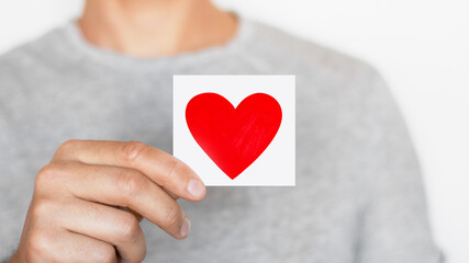 Fototapeta premium Man holding a red heart. Romantic man. Message. Love. The senses.