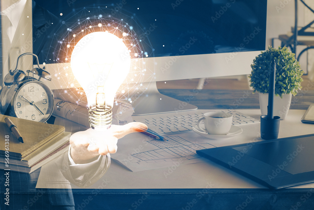 Poster computer on desktop in office with bulb icon hologram. double exposure. concept of idea.