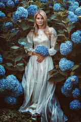 Beautiful woman among hortensia flowers