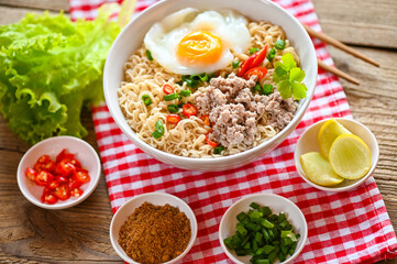 noodles bowl with boiled egg minced pork vegetable spring onion lemon lime lettuce celery and chili on table food , instant noodles cooking tasty eating with bowl - noodle soup