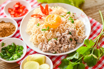 noodles plate with egg minced pork vegetable spring onion lemon lime lettuce celery and chili on table food , instant noodles cooking tasty eating with bowl noodle soup