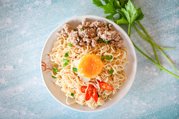 noodles plate with egg minced pork vegetable spring onion celery and chili on table food , instant noodles cooking tasty eating with bowl noodle soup