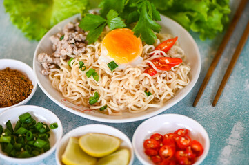 noodles plate with egg minced pork vegetable spring onion lemon lime lettuce celery and chili on table food , instant noodles cooking tasty eating with bowl noodle soup