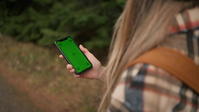 Cropped view of the hiker woman using chromakey mobile phone navigation or social media app
