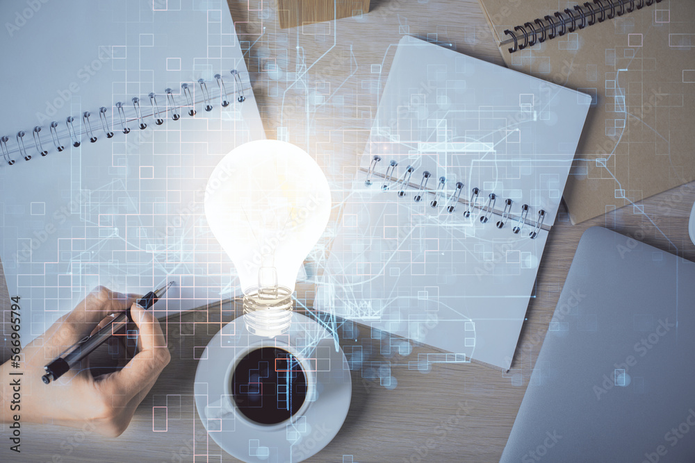 Poster bulb hologram over hands taking notes background. concept of idea. double exposure