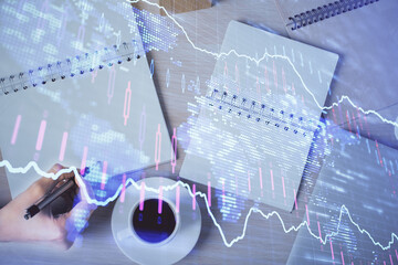 Multi exposure of woman's hands making notes with forex graph hologram. Concept of technical analysis.