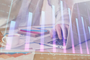 Forex graph with businessman working on computer in office on background. Concept of hardworking. Multi exposure.