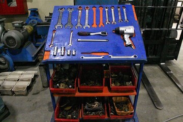 Professional car metal chrome mechanic set of various working construction tools organized on a board table. Workshop wrenches, hammer, clamps, screwdrivers. Repair instruments concept.