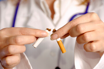 woman doctor breaking a cigarette in half, stop smoking concept