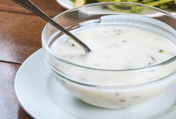 yogurt soup with herbs in a plate on a wooden table.spas