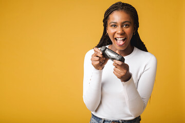 Photo of happy excited crazy smiling woman playing videogames addicted to playstation isolated on yellow colour background © Vadim Pastuh