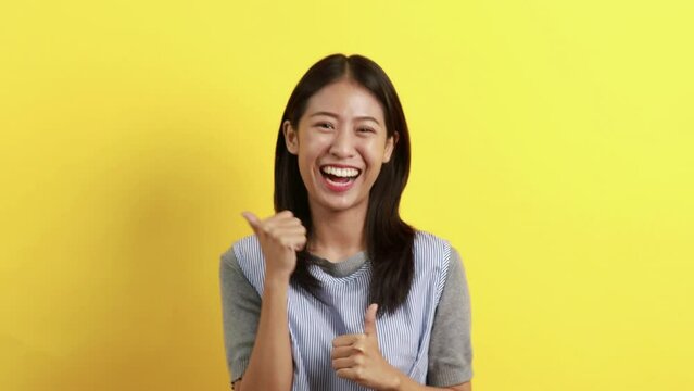 Asian woman posing extremely happy to win, Successful, Show extreme happiness, Very happy, yes, Lonely woman on yellow background.