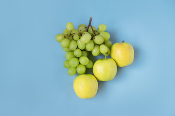 green grapes and green apples on a blue background. isolated
