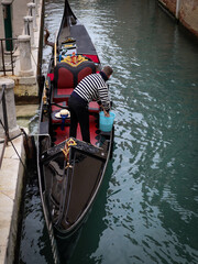 gondolier cleaning and preparing the gondola at Venice Italy
