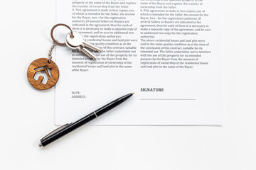 Signing a house purchase agreement concept with house shaped keychain