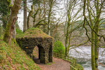 an ancient stone building on the edge of a riverbank