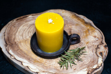 A beautiful wax candle with honey on an old clay stand. Home retro decoration. Aromatherapy concept.
