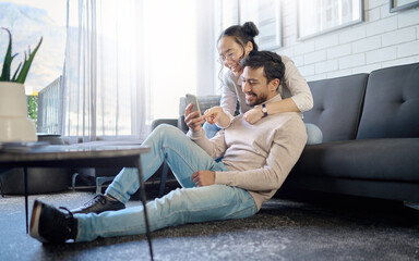 Interracial, couple and people with phone on social media laughing at meme or funny internet content. Man, woman and lovers relax in home, house or apartment browsing the web, website or app