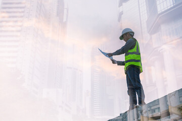 Double exposure image of engineer civil and construction worker with safety helmet and construction drawing against the background of surreal construction site in the night city or dark cityscape.