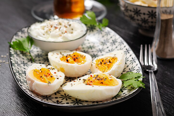Boiled eggs with yogurt, peppers, parsley and cup tea. Healthy diet food for breakfast.
