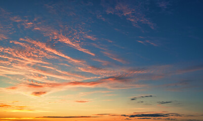 Naklejka na ściany i meble The sky before dawn, orange clouds on the background of the blue sky.