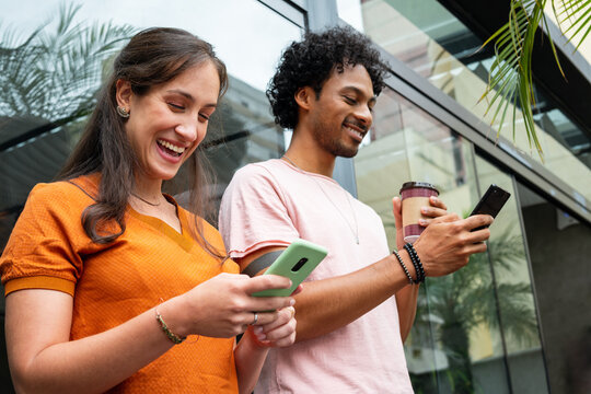 happy friends using mobile phone for fun in coffee shop