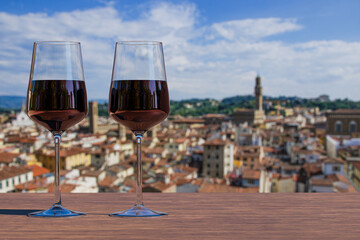 Two glass of red wine with view from above of Florence historic city center in Italy