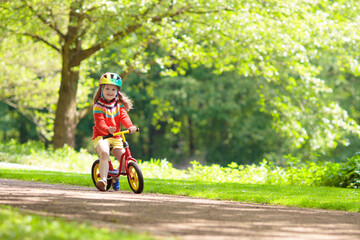 Kids ride balance bike in park