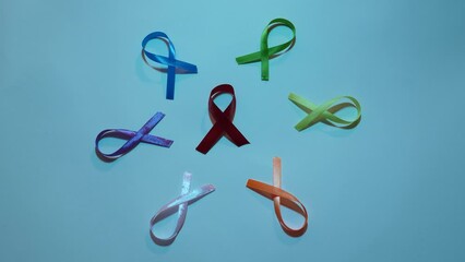 Cancer disease symbol with colored ribbons close-up on world Cancer Awareness Day , colored light