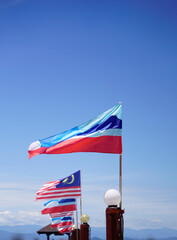 Malaysian and Sabah flags alongside the pier of Marukan Island in Sabah, Malaysia                               