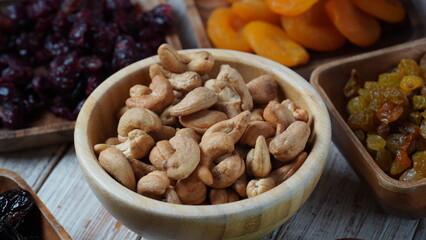Wooden bowl with mix nuts:  Walnut, pistachios, almonds, hazelnuts and cashews on a table
