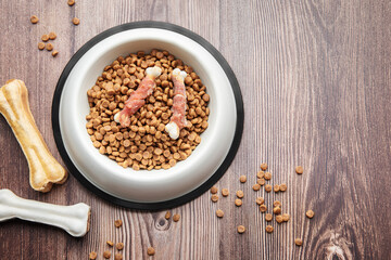 A bowl of dog food on a wooden floor.