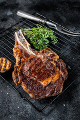 BBQ Grilled Tomahawk or rib eye with bone beef steak. Black background. Top view