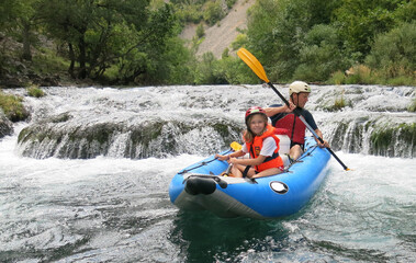 Father and daughter go river rafting in Croatia. Family travel traditions.  Paddling in the river