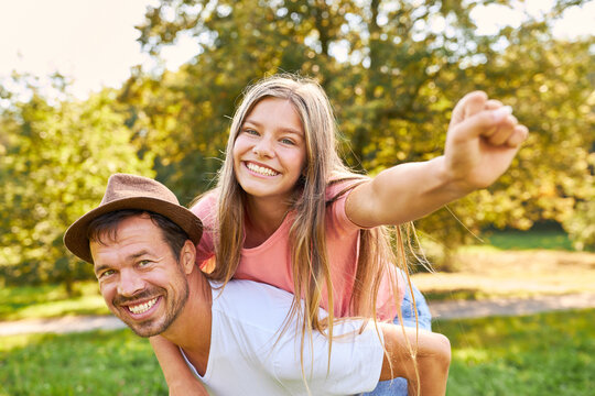 Happy father giving his daughter piggyback ride