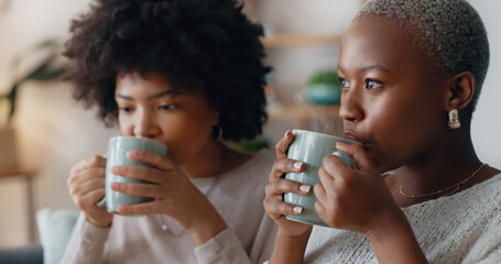 Chocolate drink and black woman friends on sofa talking and having winter celebration. African people or gen z women enjoying sweet milk coffee or cocoa beverage on couch in their apartment lounge