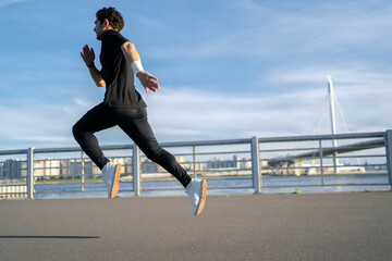A man running fast in a sports uniform. Fitness training outdoors.