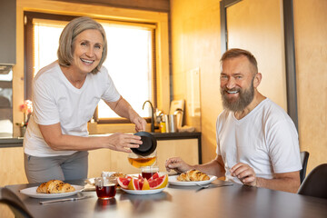 Happy couple having breakfast and feeling comfortable